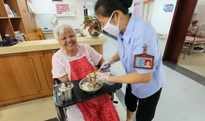 图：广东首批“最美养老护理员”、广州市黄埔区老人院养老护理员李彩燕悉心照料老人（照片摄于2017年）